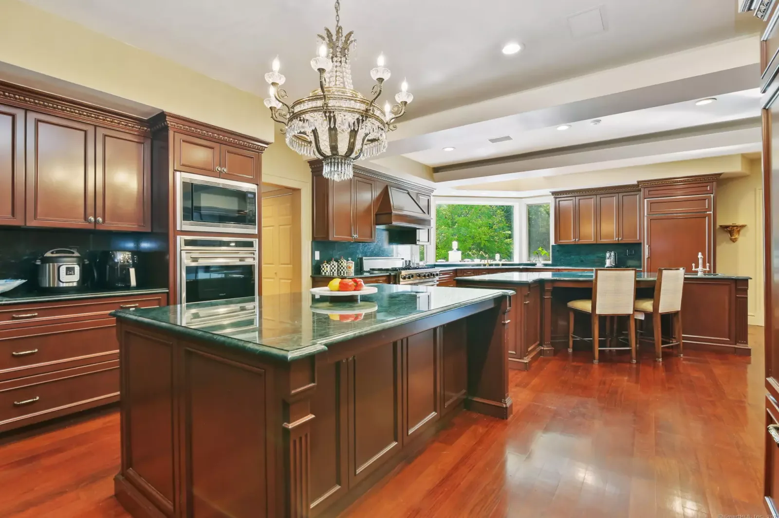 The main kitchen's island, under a chandelier.