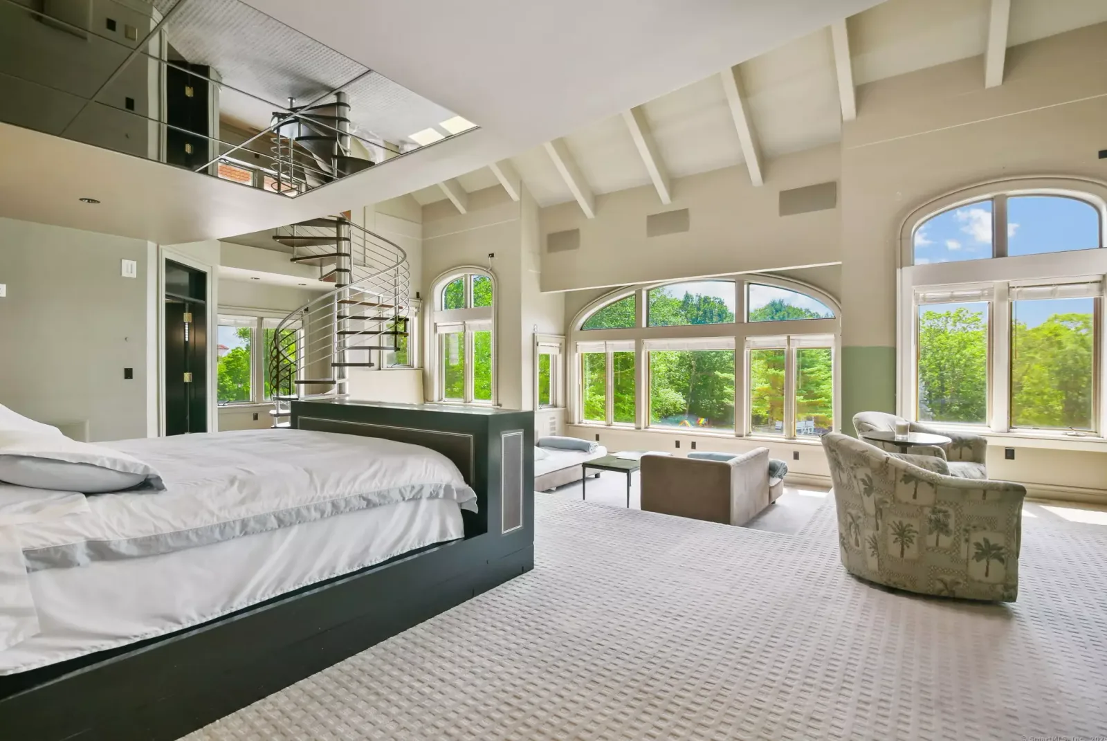 The primary bedroom, with a spiral staircase to the level above.