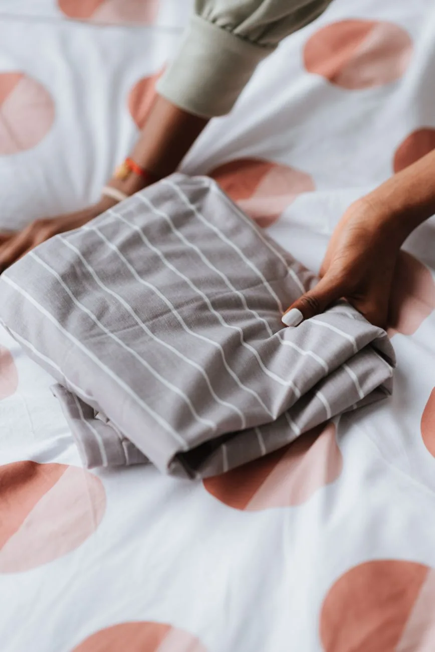 Nest all four elastic corners inside out to fold a fitted sheet flat